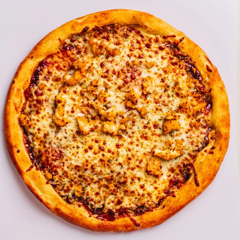 A whole PizzaMe! BBQ chicken pizza with melted cheese and a golden crust.